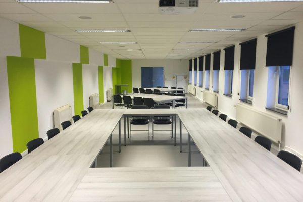 White Wooden Table and Black Chairs Inside White Green Painted Room